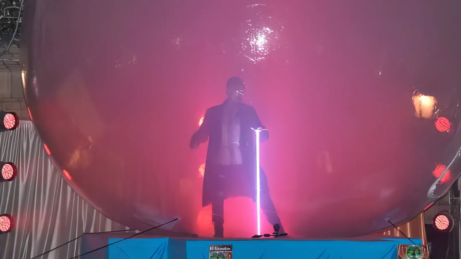 El Guardián dentro de la esfera sosteniendo un haz de luz vertical, en la plaza durante el encendido